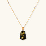 18k gold-plated necklace and earrings with green amber pendants featuring golden inclusions on cream background