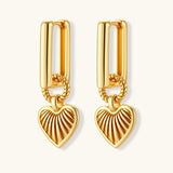 Gold-plated huggie earrings with textured heart charms featuring radiating sunburst patterns on white background.