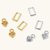 Silver huggie earrings with textured heart charms featuring radial sunburst pattern on neutral background.