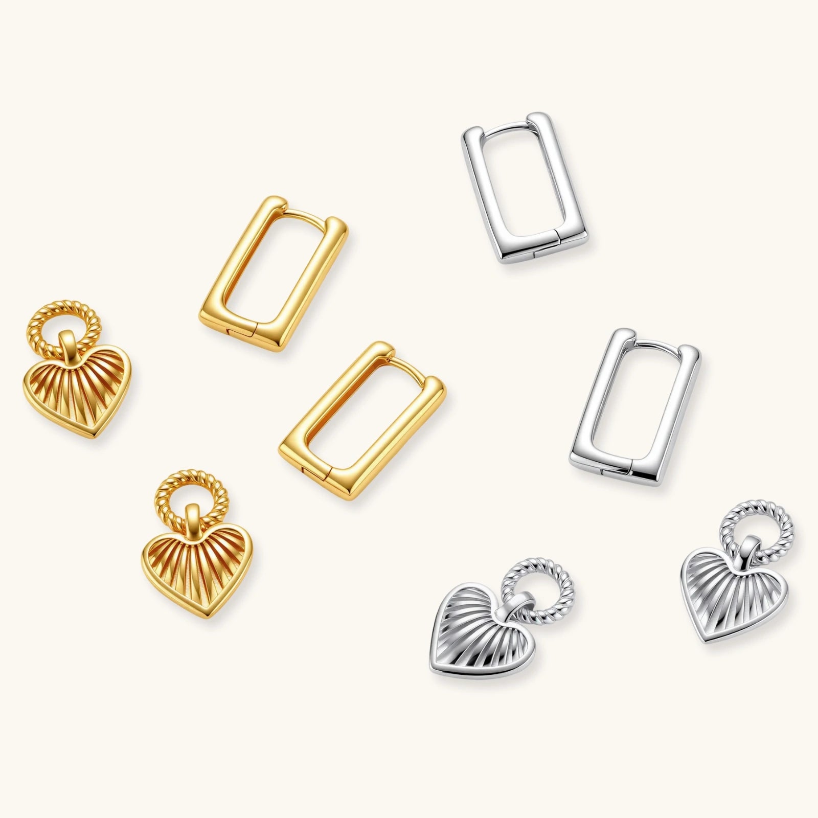 Silver huggie earrings with textured heart charms featuring radial sunburst pattern on neutral background.
