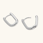 Close-up of platinum-plated sterling silver huggie hoops with pavé crystal setting on white background.