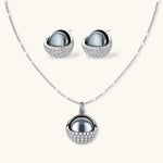 White gold plated spherical jewelry set with zirconia crystal pavé and dark lustrous centers on neutral background.