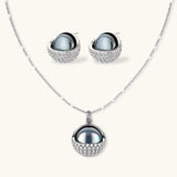 White gold plated spherical jewelry set with zirconia crystal pavé and dark lustrous centers on neutral background.
