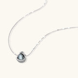 White gold plated spherical jewelry set with zirconia crystal pavé and dark lustrous centers on neutral background.