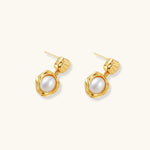 Gold-plated textured stud earrings with white freshwater pearl drops against cream background, showing organic rippled design