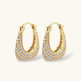 Gold-plated hoop earrings fully covered in sparkling zircon crystals with hinged closure on neutral background