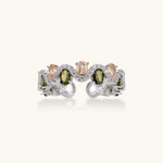 Adjustable copper ring with platinum plating, featuring alternating peach and green zirconia stones in organic wave pattern