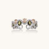 Adjustable copper ring with platinum plating, featuring alternating peach and green zirconia stones in organic wave pattern