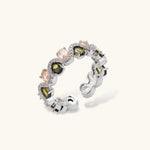 Adjustable copper ring with platinum plating, featuring alternating peach and green zirconia stones in organic wave pattern