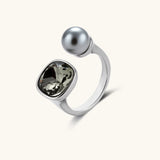 Modern adjustable ring with smoky zircon stone and metallic sphere in platinum-plated copper finish on neutral background.