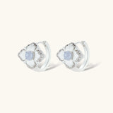 Silver-plated flower earrings with blue zirconia centers, featuring one stud and one huggie hoop in mismatched pair style.