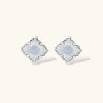 Silver-plated flower earrings with blue zirconia centers, featuring one stud and one huggie hoop in mismatched pair style.