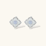 Silver-plated flower earrings with blue zirconia centers, featuring one stud and one huggie hoop in mismatched pair style.