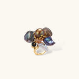 Adjustable gold-plated ring featuring clustered dark baroque pearls in organic arrangement on white background.