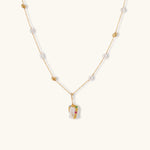 Delicate 18k gold-plated chain with baroque pearls and colorful enamel pendant featuring blue, pink accents on cream background.