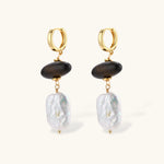 Gold hoop earrings with dark wood beads and baroque freshwater pearls, shown from multiple angles on cream background.