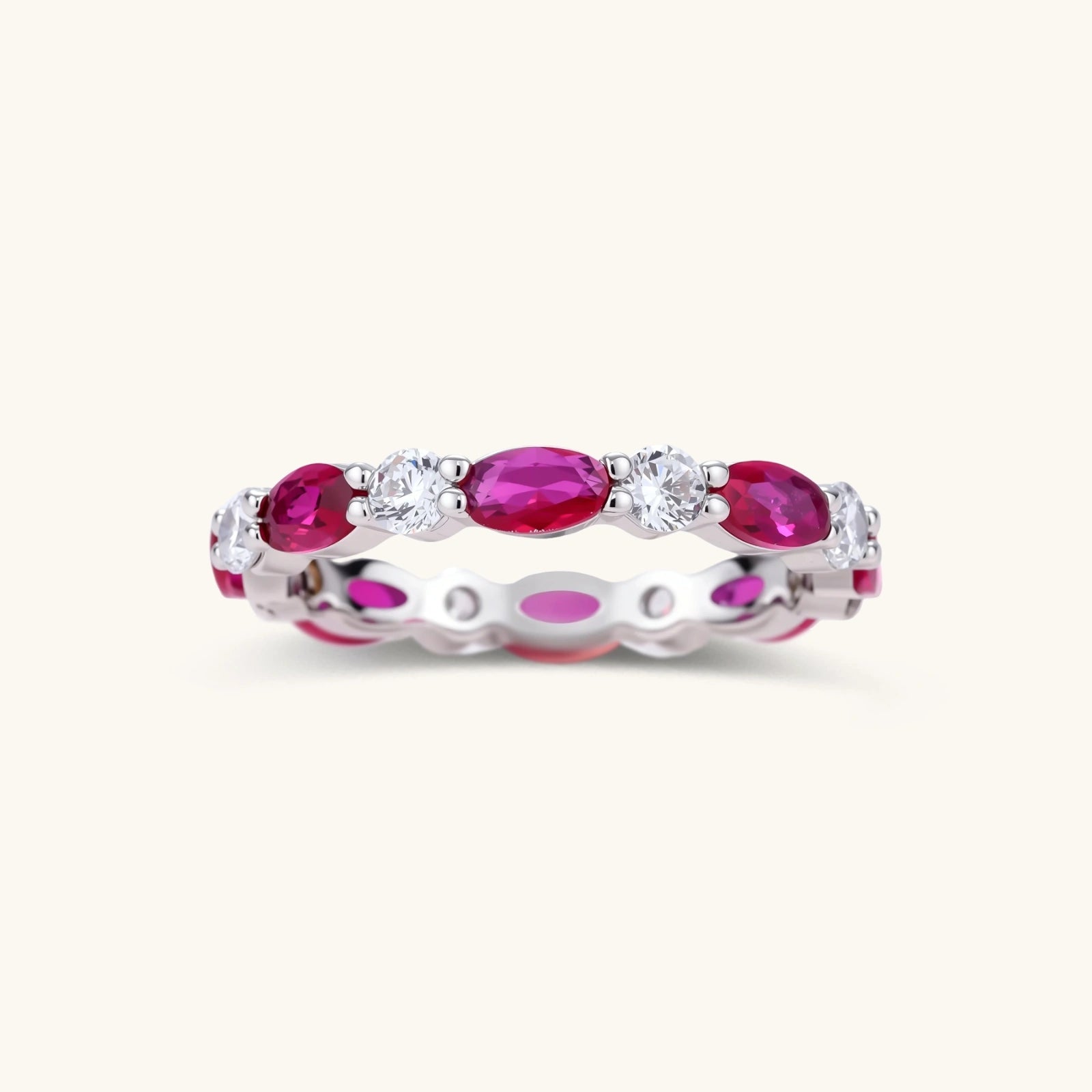 Platinum-plated eternity ring with alternating oval ruby and round clear stones in continuous band setting