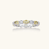 Platinum-plated copper ring with alternating clear and pale yellow oval stones in an eternity band design on white background.
